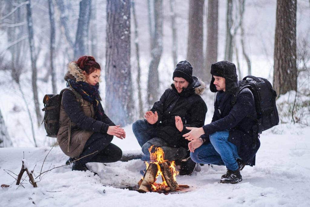 friends hike snowy forest young hikers heated by fire 1